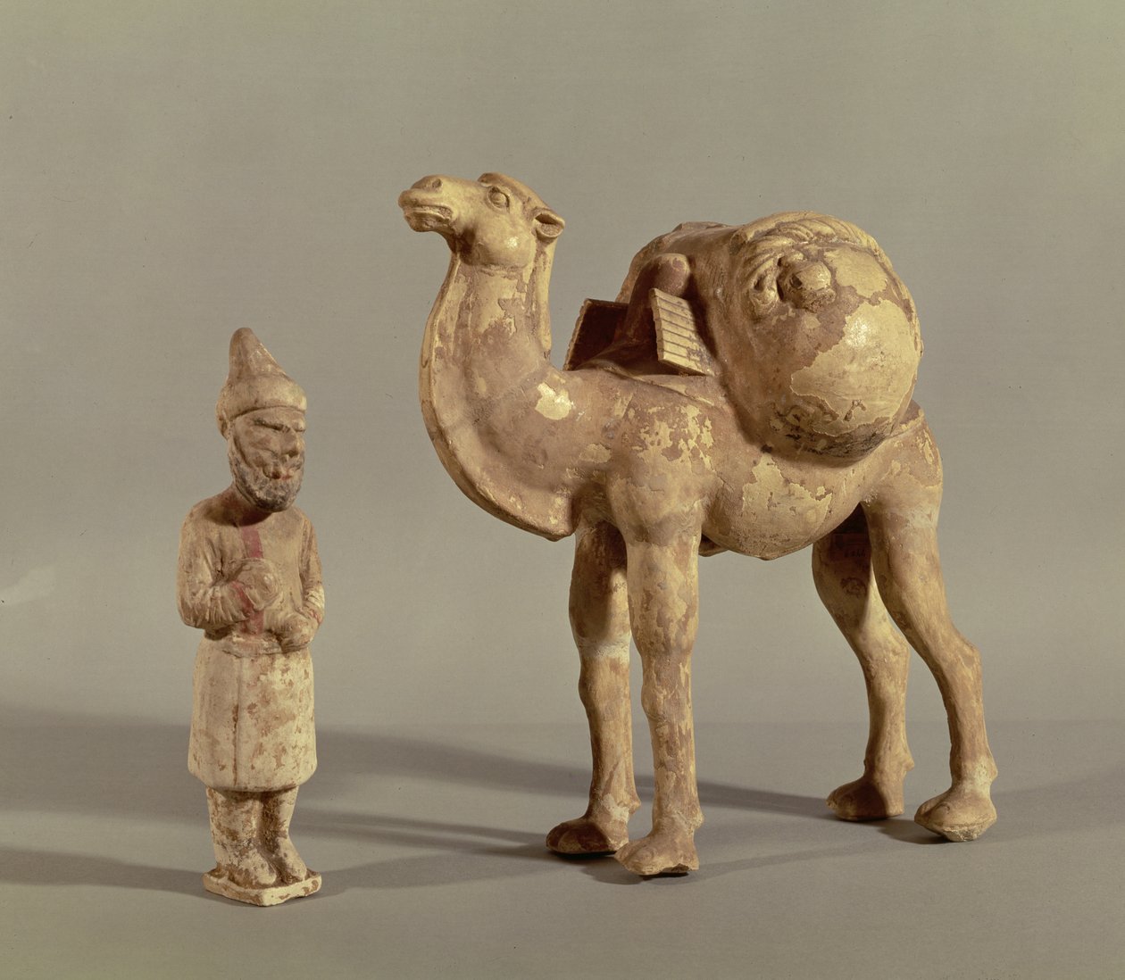 Funerary statuettes of a laden camel and a barbarian caravanner, Tang Dynasty by Chinese School