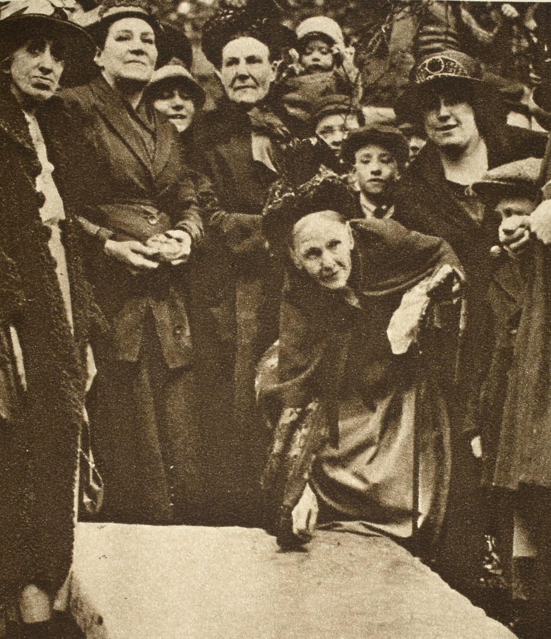 Poor widows pick up sixpences from a tombstone on Good Friday by English Photographer