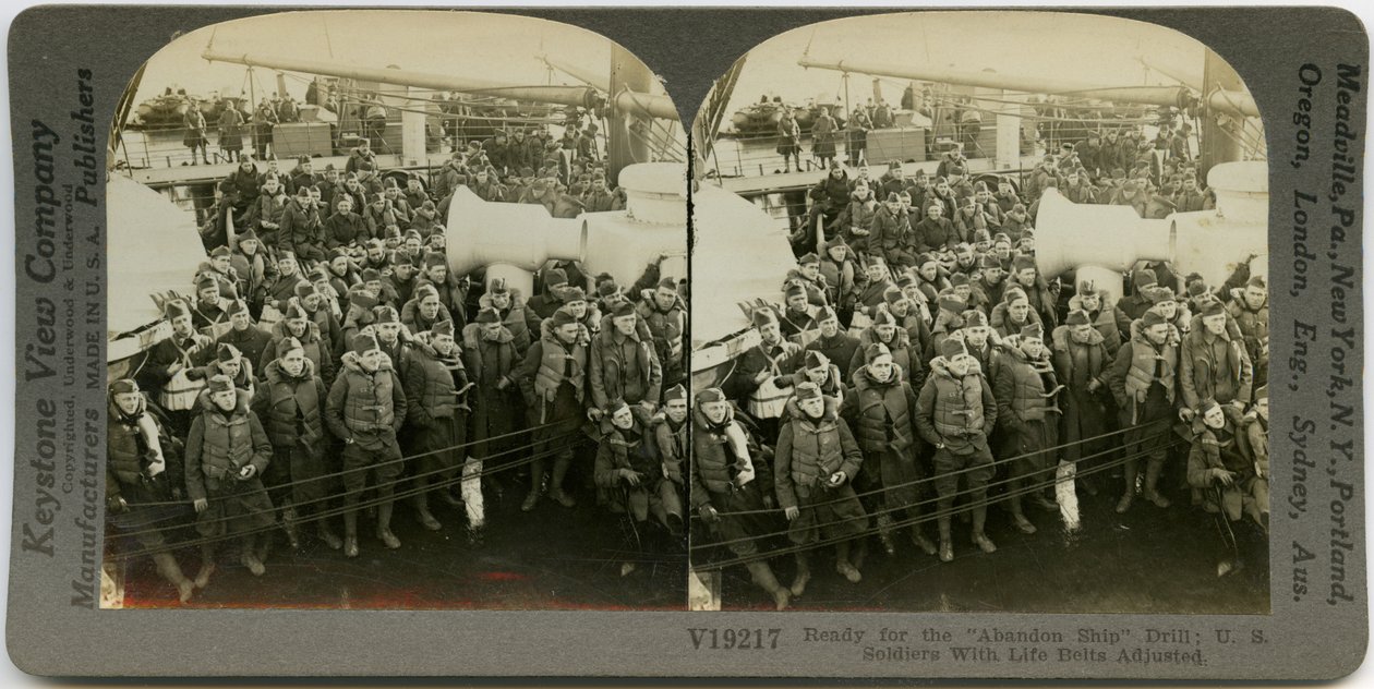 Horizontal, Sepia Stereocard Showing Uniformed American Soldiers Wearing Life Vests Standing and Sitting on the Deck of a Ship. Keystone Stereograph Number V19217. The Title Reads by Keystone View Company