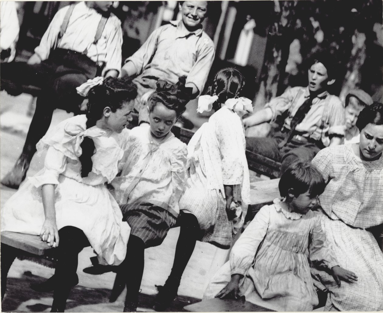 A group of children playing on teeter-totters in a park by Unknown