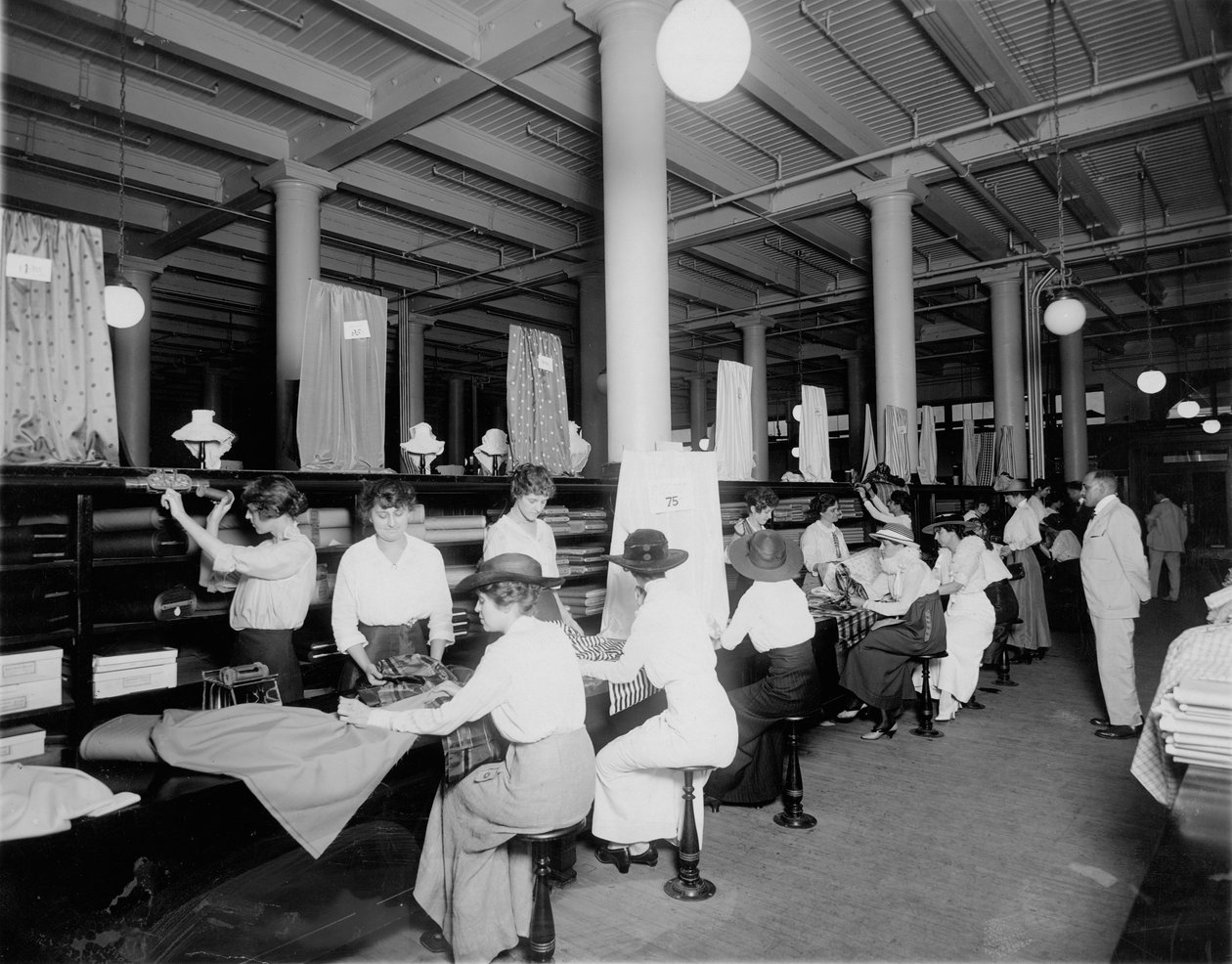 Interior of fabric store. Measuring and cutting fabric for customers by W.C. Persons