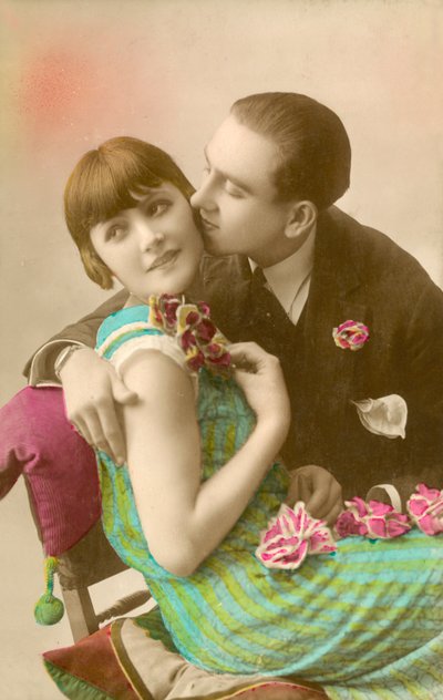 Young man kissing girl on cheek by French Photographer